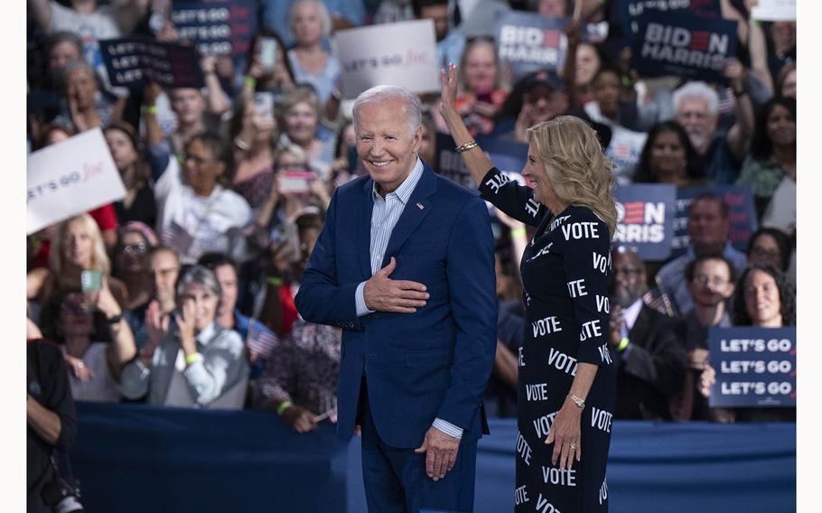 U.S. President Joe Biden and first lady Jill Biden, with “VOTE” printed on her dress, gesture to supporters at a post-debate campaign rally on June 28, 2024, in Raleigh, North Carolina. 