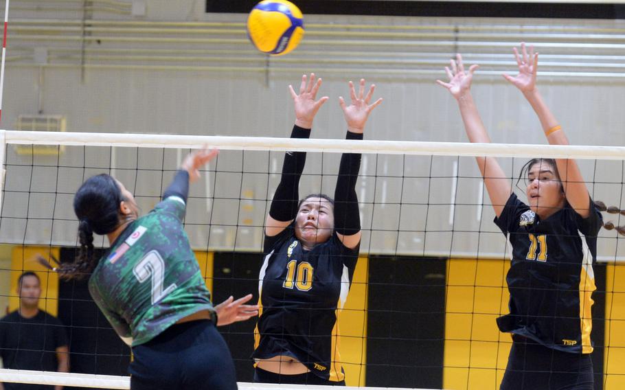 Kubasaki's Runa Holladay spikes against Kadena's Christina Kehe and Leighton Botes during Tuesday's Okinawa girls volleyball match. The Panthers won in straight sets.