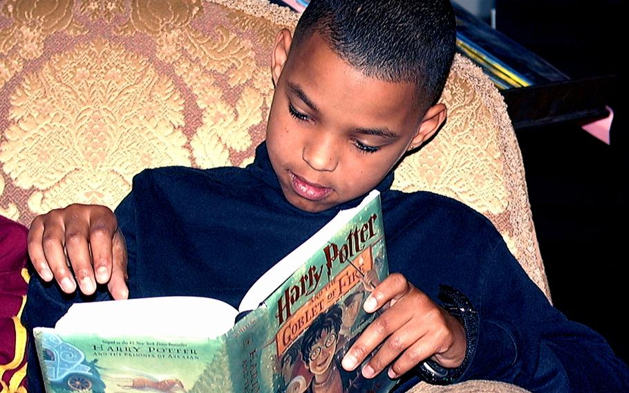 A fifth grader at Liberty Intermediate School at RAF Lakenheath, England, reads “Harry Potter and the Goblet of Fire” at the school library in this undated photo. 