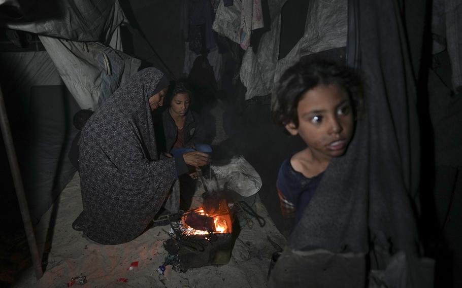 Displaced Palestinians at a fire near their tent in Deir al-Balah in the Gaza Strip.