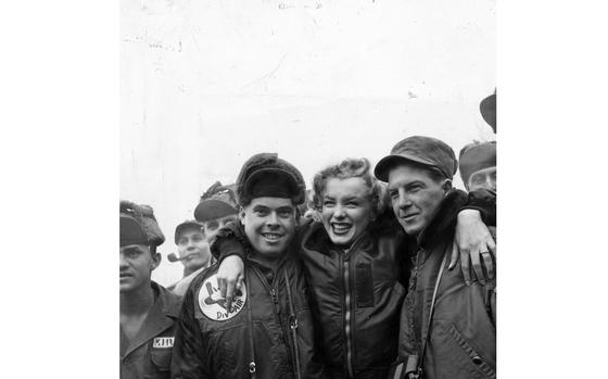 HED: Marilyn Monroe in Korea, 1954

Actress Marilyn Monroe poses with Pfc. John Fenesy of Caldwell, N.J., 3rd Div. air section, left, and Cpl. Dick Armstrong of Williston Park, N.Y., 13th Helicopter Co, at the 3rd Division ("Rock of the Marne") airstrip Feb. 18, 1954. Armstrong was the crew chief on the helicopter that brought the star to her show, which drew thousands of servicemembers. The blond bombshell accompanied her husband Joe DiMaggio as he flew to Japan to assist the Japan Central League start training for the 1954 season, but Monroe detoured with a jaunt to South Korea to entertain the troops. 

Read the 1954 article and see additional photos here.
https://www.stripes.com/theaters/asia_pacific/1954-02-23/6,000-thunderbirds-stampede,-mob-stage-to-see-marilyn-1821660.html

META TAGS: USO; entertainment; celebrity; actress; performer; 3rd Infantry Division.