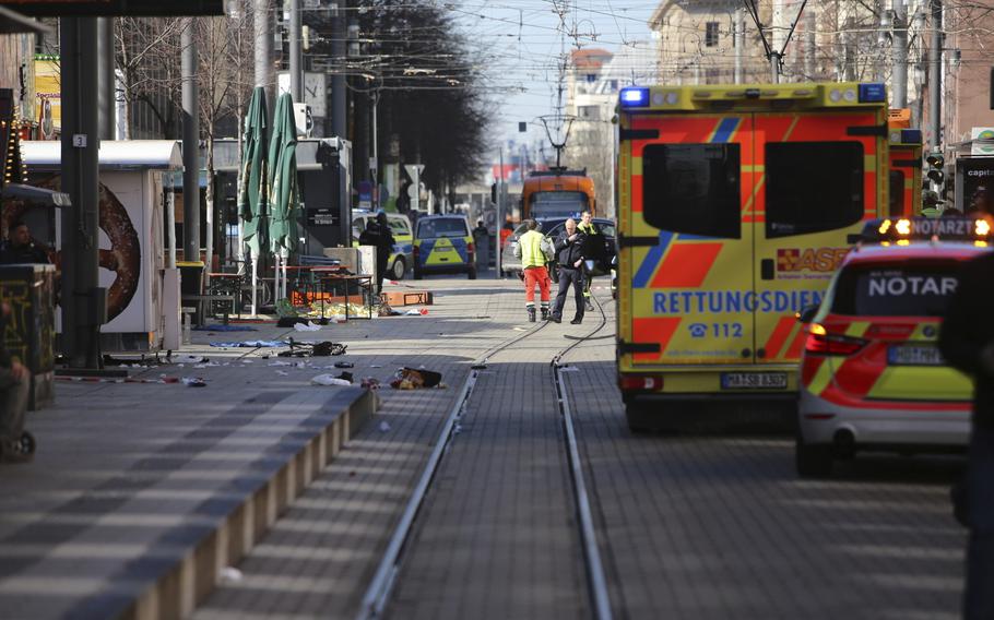 Emergency vehicles and first responders stand along tram tracks in downtown Mannheim. 