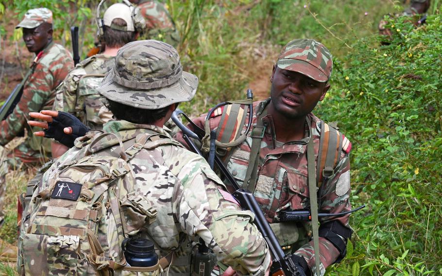 A Beninese soldier from the 1st Commando Parachute Battalion and a U.S. Army Green Beret assigned to 3rd Special Forces Group discuss squad movements during a training exercise in Ouassa, Benin, in 2022. 