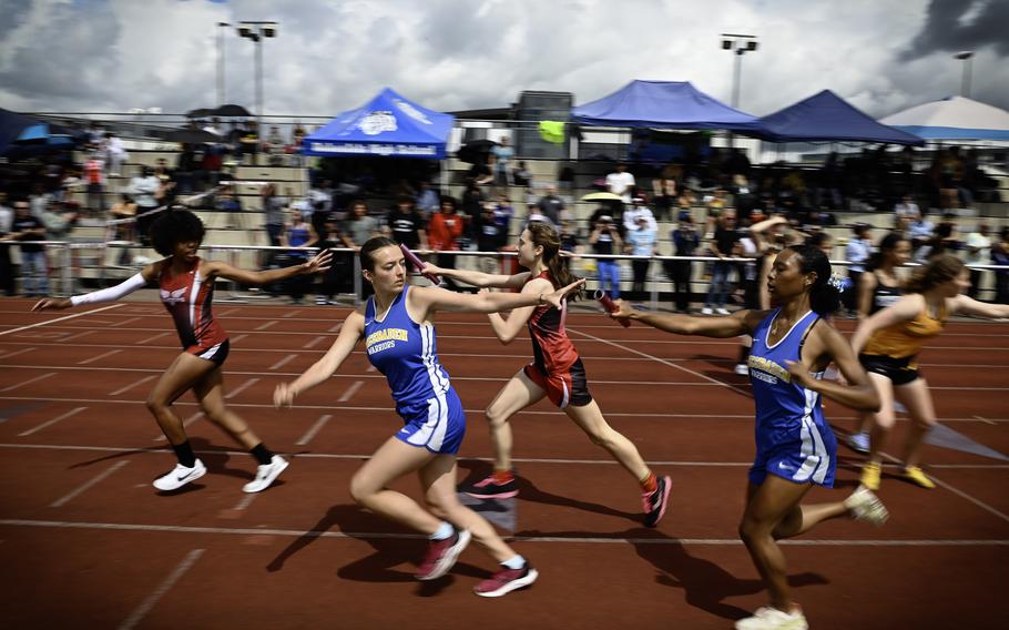 Teams from Wiesbaden and Kaiserslautern exchange the baton during the girls 4x800 meter varsity relay at the 2024 DODEA European Championships at Kaiserslautern High School in Kaiserslautern, Germany, on May 24, 2024.