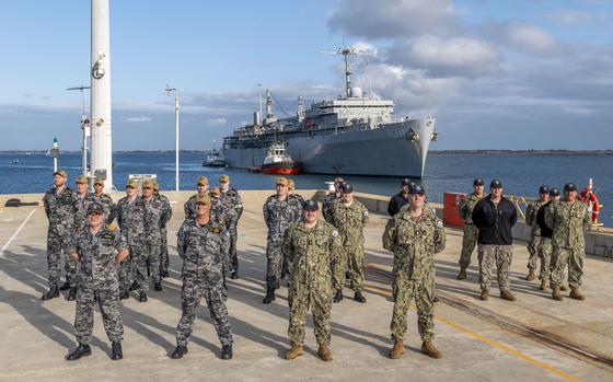 U.S. and Australian sailors stand in formation as the submarine tender USS Emory S. Land prepares to moor at HMAS Stirling, a navy base near Perth, Australia, Aug. 16, 2024. 