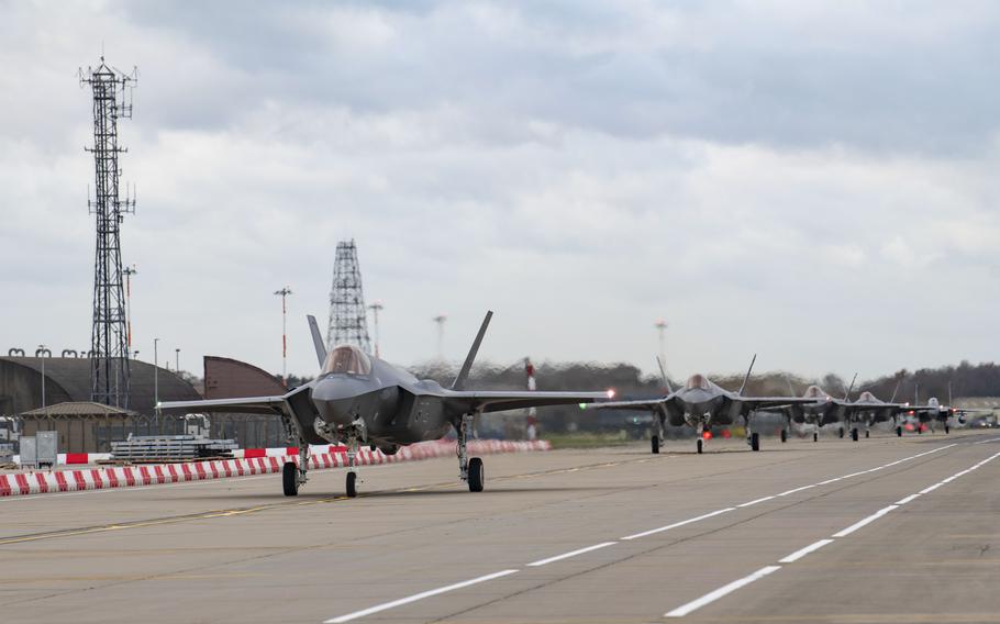 A fighter jet with wheels down on a runway.