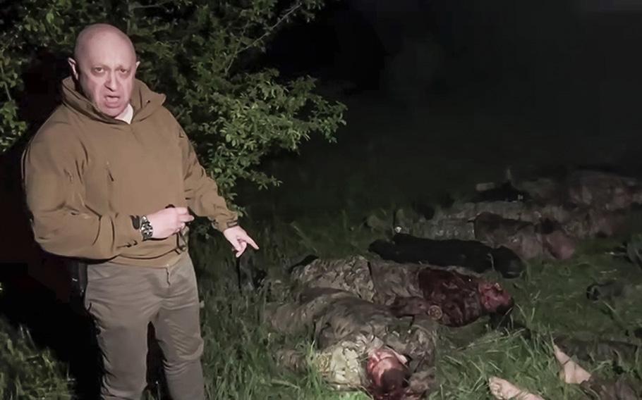 A screen grab from a video posted on May 5, 2023, shows Yevgeny Prigozhin, head of Wagner Group, as he stands in front of multiple bodies lying on the ground in an unknown location. Prigozhin targeted Russian military leaders with expletive-riddled insults, blaming them for the failure to provide his troops with enough ammunition.