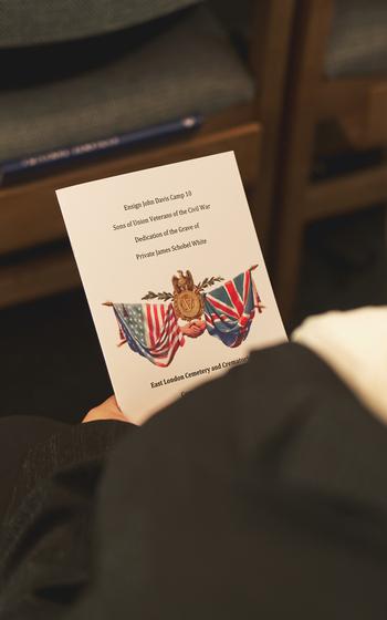 A family member of Pvt. James Schobel White holds the program created by the Sons of Union Veterans of the Civil War in the East London Cemetery Chapel, Aug. 10, 2024. 