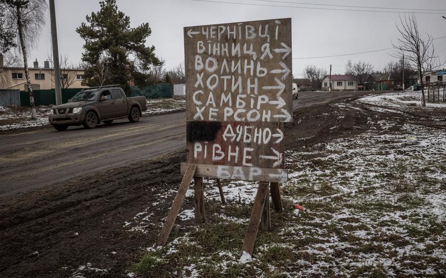 A sign with the names of cities.