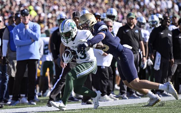 Navy defense end Luke Pirris tackles and pushes out of bound Tulane wide receiver Bryce Bohanon during the Navy-Tulane NCAA college football match, Nov. 16, 2024.