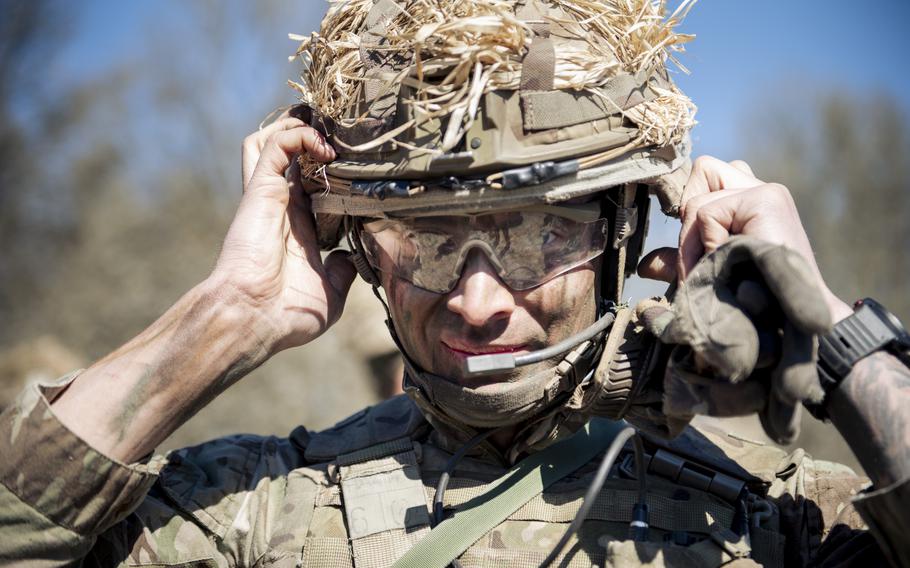 A Royal Military Academy Sandhurst cadet adjusts his helmet. 