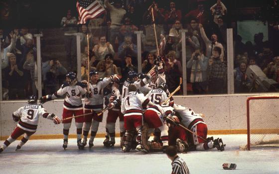 FILE - In this Feb. 22, 1980, file photo, the U.S. hockey team pounces on goalie Jim Craig after a 4-3 victory against the Soviets in the 1980 Olympics, as a flag waves from the Lake Placid, N.Y. crowd. (AP Photo, File)