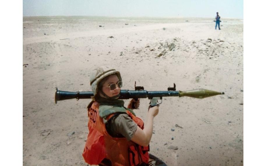 Bell Crause holding an explosive weapon in the desert