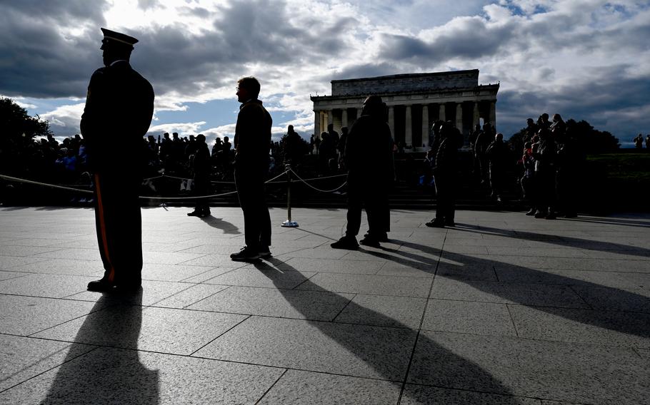 Service members stand in front of the Lincoln Memorial.