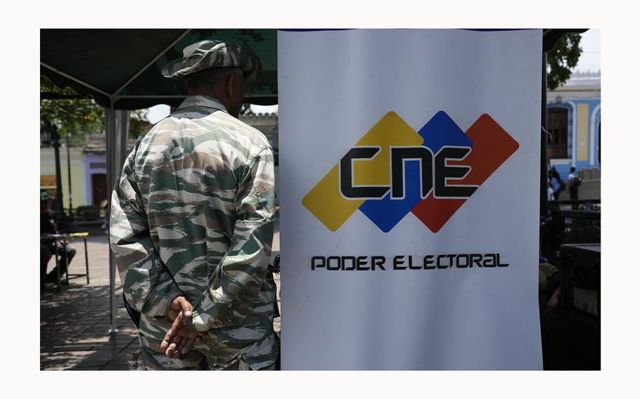 A Bolivarian militia member stands on guard next to a banner of the National Electoral Council where people can register to vote in the presidential election in Caracas, Venezuela, April 16, 2024. On May 28, 2024, Venezuela’s electoral authorities revoked an invitation for a European Union mission to observe the country’s July 28 presidential election. 
