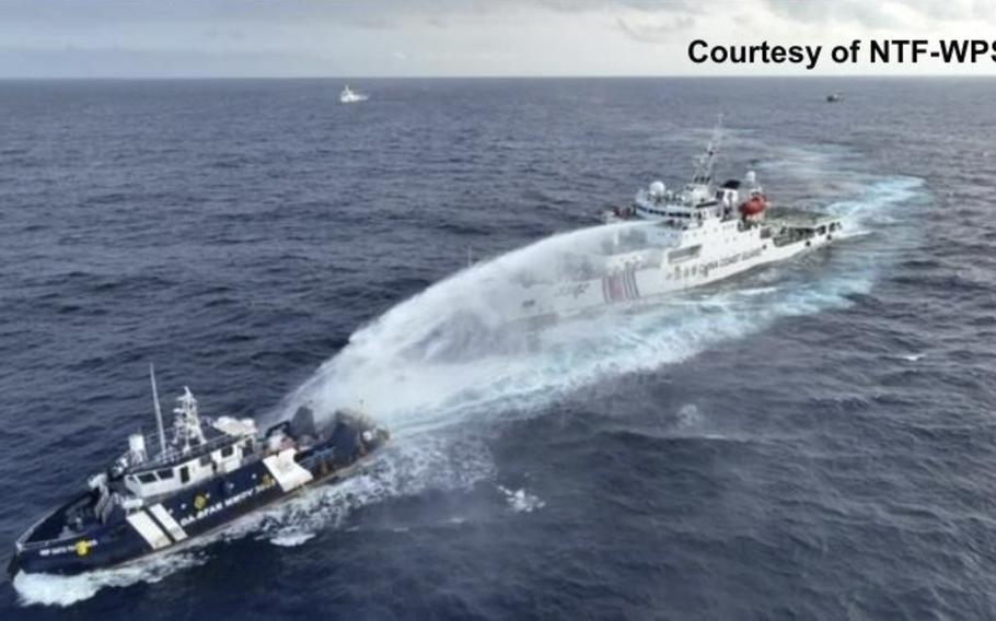 A Chinese vessel shoots a water cannon onto a Filipino vessel in the sea.