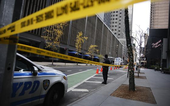 A New York police officer stands on 54th Street outside the Hilton Hotel in midtown Manhattan where Brian Thompson, the CEO of UnitedHealthcare, was fatally shot Wednesday, Wednesday, Dec. 4, 2024, in New York. (AP Photo/Stefan Jeremiah)