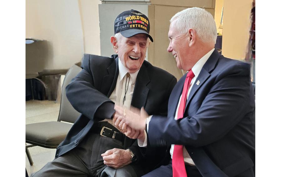 World War II veteran Robert Pedigo, left, shakes hands with former Vice President Mike Pence in March at a ceremony in Indianapolis marking National Medal of Honor Day. Pedigo will be attending ceremonies in Normandy marking the 80th anniversary of the D-Day landings, in which he took part as a crew member of a B-24J Liberator bomber.