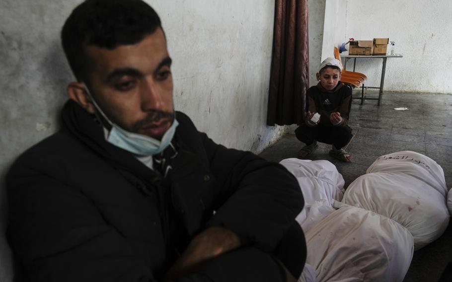 Family members mourning next to the bodies of their family.