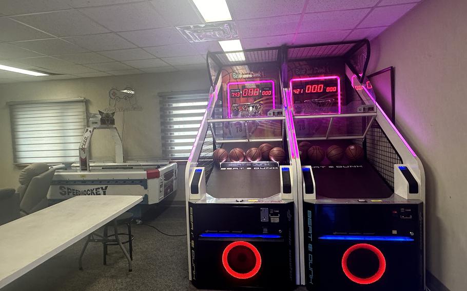 The inside of dormitory dayrooms at Kunsan Air Base showing an air hockey table and basketball shooting game.