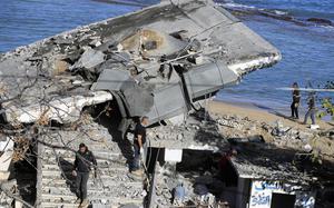 Lebanese Army Intelligence members walk around and survey a site damaged by an Israeli airstrike, in Sarafand, Lebanon, Nov. 20, 2024.