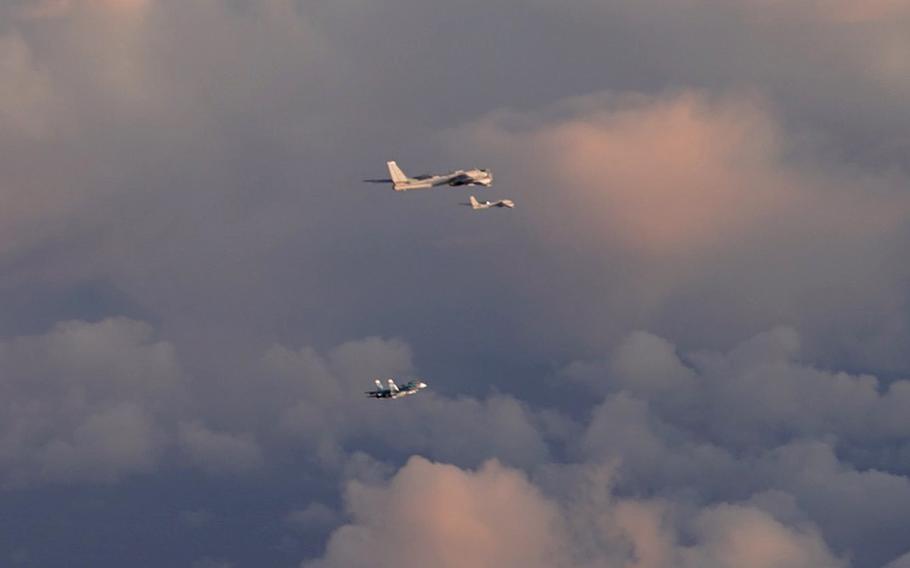 Two Russian Tu-95 strategic bombers are escorted by a fighter fly north of Norway.