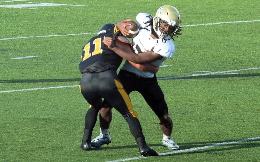 Humphreys' Matthew Nubin tries to break free of Kadena defender Hajime Reed. Reed blocked a punt for a safety.