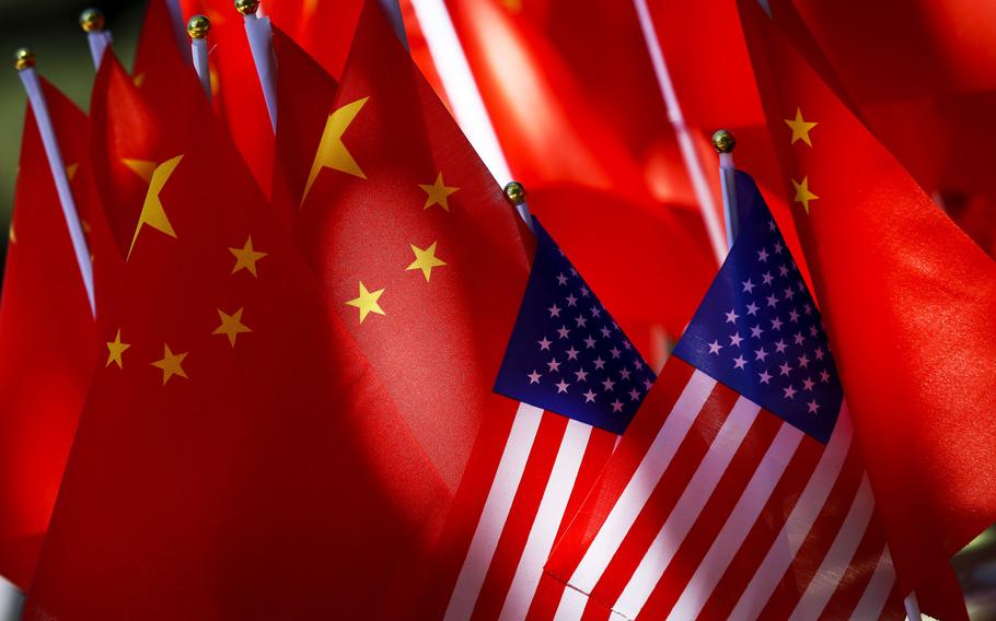 American flags are displayed together with Chinese flags on top of a trishaw in Beijing, Sept. 16, 2018.