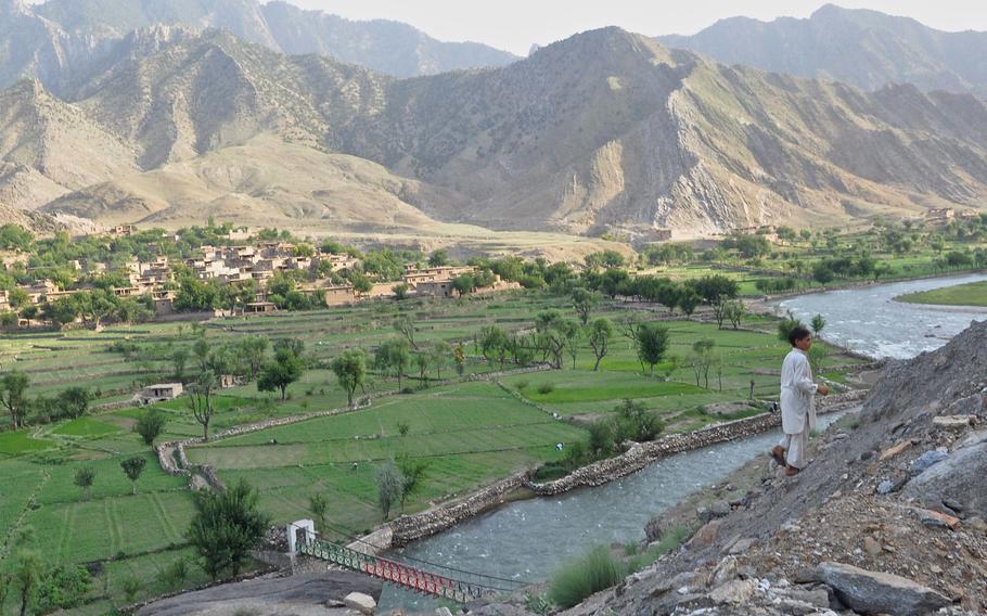 A child walks up from the valley along the Pech River in Kunar province to his home on the road above in Qandaro village.