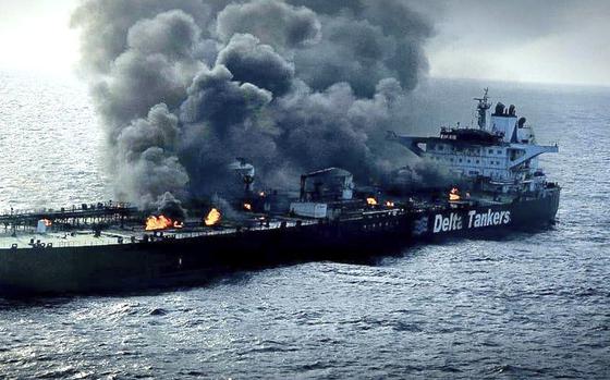  An oil tanker is shown on fire with smoke billowing from it. 