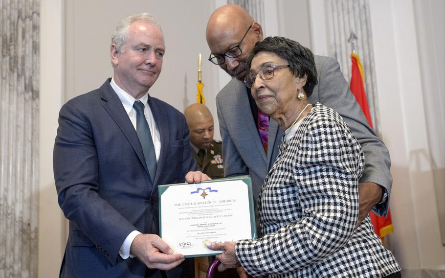 Sen. Chris Van Hollen, D-Md., left, presents the Distinguished Service Cross to Joann Woodson, center, and her son Steve Woodson, right, during a ceremony to posthumously honor her husband, U.S. Army Staff Sgt. Waverly Woodson, Jr., in Washington on Sept. 24, 2024.