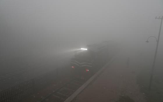 A commuter train moves with headlights as smog envelops the area of Lahore, Pakistan, Monday, Nov. 11, 2024. (AP Photo/K.M. Chaudary)