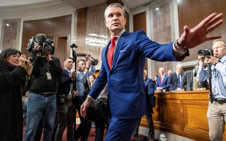 Hegseth walks and waves to senators.