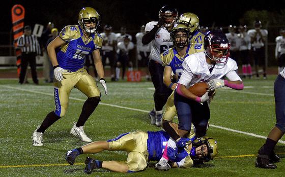 Wiesbaden defender Munro Davis tackles Lakenheath running back Aaron Valiente during a Division I first-round playoff game on Oct. 18, 2024, at Wiesbaden High School in Wiesbaden, Germany.