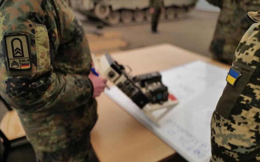 Ukrainian soldiers and a German instructor examine the internal control cluster of a Leopard 1 A5 tank during a technical training session on June 13, 2024, at the Klietz military range in Germany.