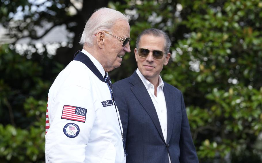 President Joe Biden and Hunter Biden, both wearing sunglasses, walk together outside.