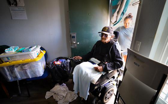 Delmar Dreaming Bear, 73, is helped into his motel room by his daughter, Dakotah Dreaming Bear.  (Nelvin C. Cepeda / The San Diego Union-Tribune)