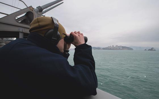 Petty Officer 2nd Class Thomas Gammon, of Georgetown, Texas, stands lookout aboard the aircraft carrier USS Carl Vinson as it pulls into Busan, South Korea, for a scheduled port visit, March 2, 2025.