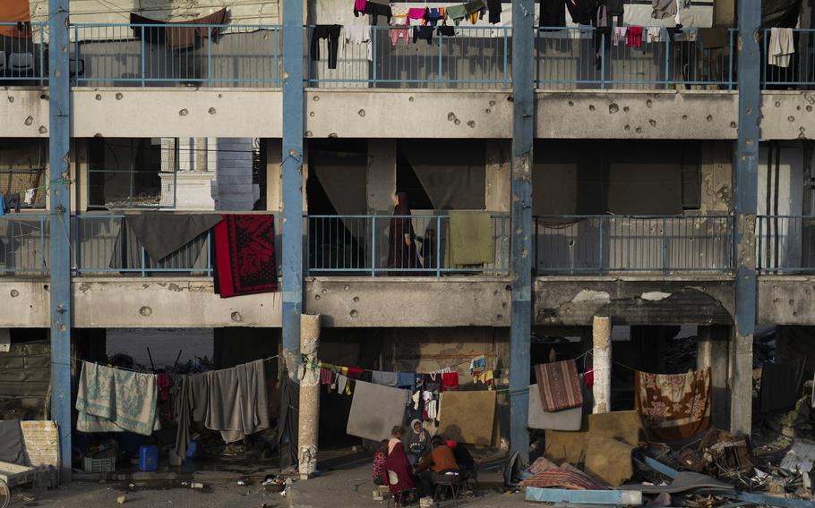 Displaced Palestinians sit in the courtyard of a school where they live.