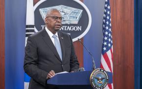 Lloyd Austin speaks while standing at a podium in front of the Pentagon emblem and a U.S. flag.