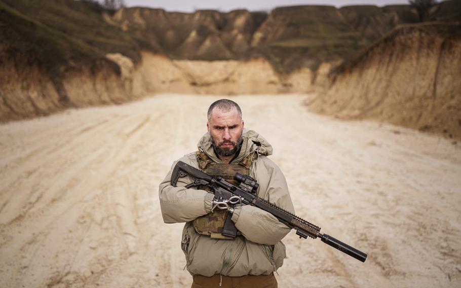 A Ukrainian soldier who lost both arms and a leg in combat holds a rifle during military training.