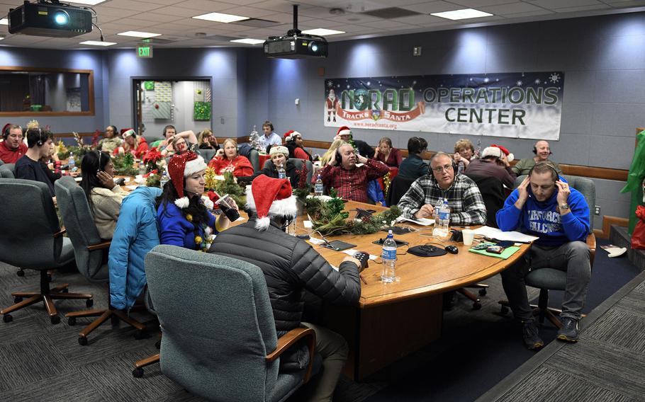 Volunteers at the NORAD Tracks Santa Operations Center in Colorado Springs, Colo., inform callers of Santa's location and the number of gifts he's delivered Dec. 24, 2022. 