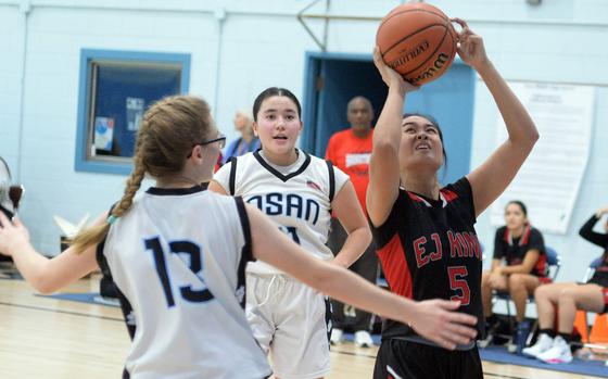 King's Claire Delpiler shoots against Osan's Hanna Rutland and Chloe Harman.