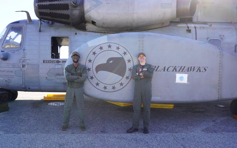 AWS2 Williams Davaris (left) and AWS3 Mark Laird pose in front of a MH-53E Sea Dragon helicopter