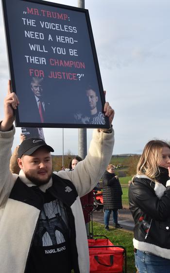 A person holds a sign as he protests outside a U.S. Air Force base in Germany.