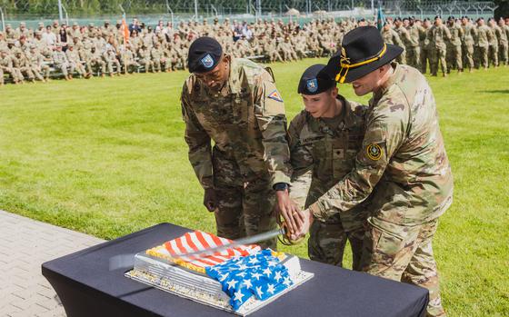 Command Sgt. Maj. Errol H. Brooks, Spc. Huymaier, and Command Sgt. Maj. Dennis Doyle cut a cake to celebrate the Army's 249th birthday during the graduation of class 07-24 of the 7th Army Training Command's Noncommissioned Officer Academy (NCOA) Basic Leaders Course in Grafenwoehr, Germany, June 12, 2024. The NCOA trains and develops future leaders who are adaptive, disciplined and ready to lead effectively at the squad and team levels. (U.S. Army photo by Sgt. Christian Carrillo)