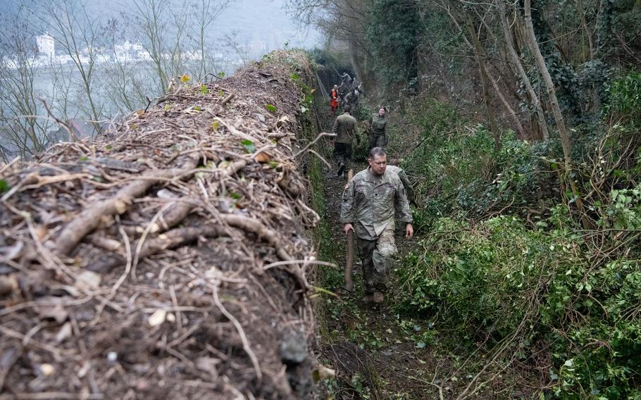U.S. and German soldiers remove vegetation that was growing on and around a centuries-old wall in St. Goar, Germany, on Feb. 23, 2023.