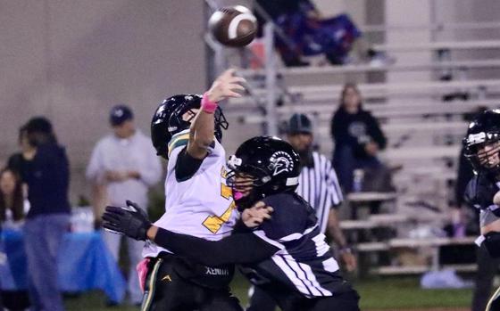 Edgren quarterback Haruki Jones is hit by Zama's Toro McClendon as he throws.