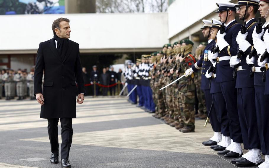 French President Emmanuel Macron reviews the troops during a military ceremony 