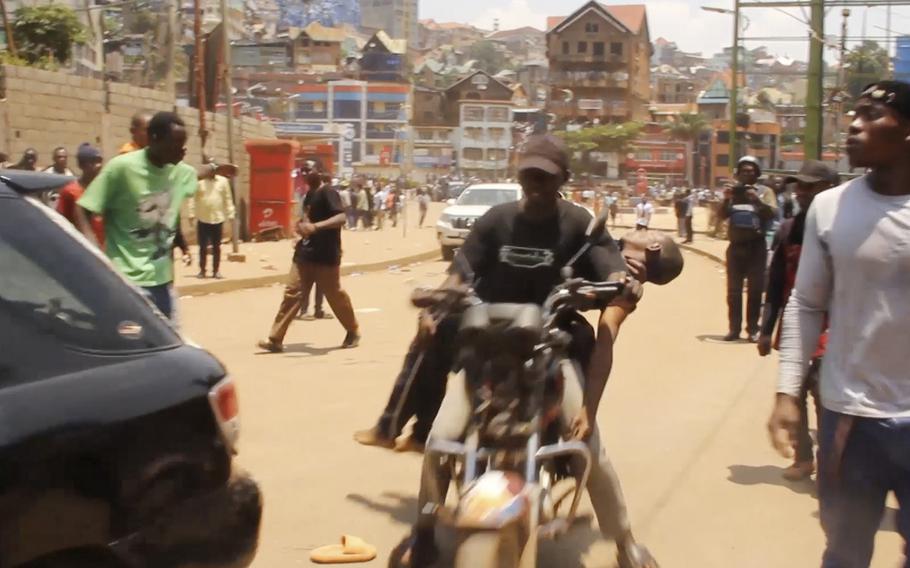 A man carries an injured boy on his bicycle.